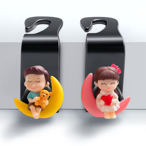 The 2pcs Universal Car Headrest Hook is a cute couple car hanger that can be used to hang and store items such as clothes in a car-Model 56-3